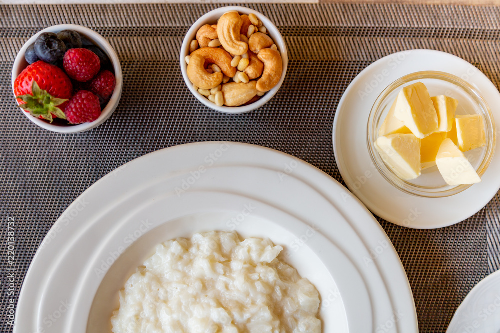 Healthy breakfast. Rice porridge bowl with berries and nuts on the table, hot and healthy breakfast food, top view Healthy breakfast. Rice porridge bowl with berries and nuts on the table, hot and healthy breakfast food, top view