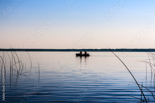 boat with fishermen swims along the lake