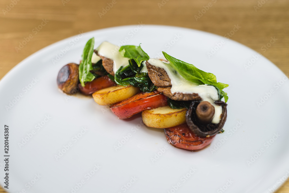 vegetables and mushrooms grilled with basil, on a white plate