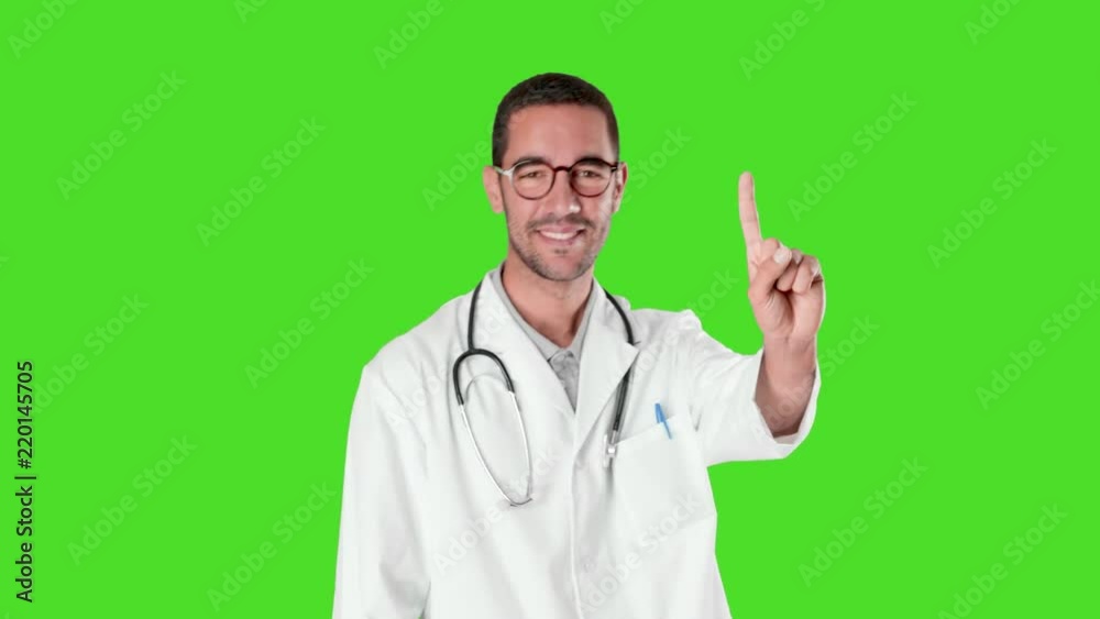 Happy young doctor doing a gesture of number one against green background