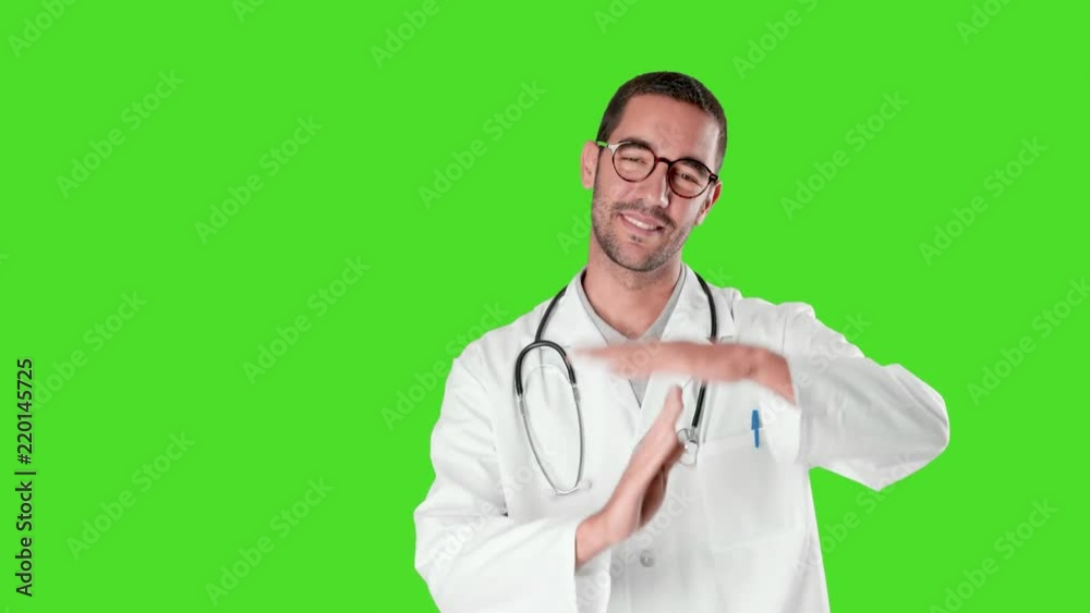 Happy young doctor doing a gesture of break time against green background Happy young doctor doing a gesture of break time against green background