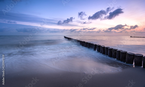 Wellenbrecher im Meer im Sonnenaufgang © Andy