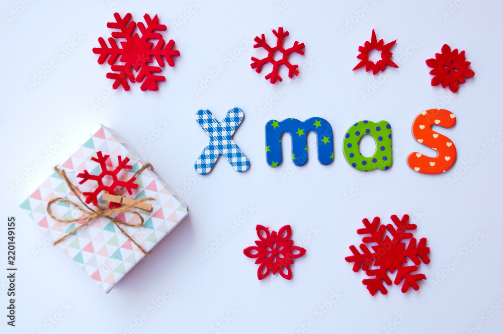 Christmas card with gift box, word xmas and red snowflakes on white background.