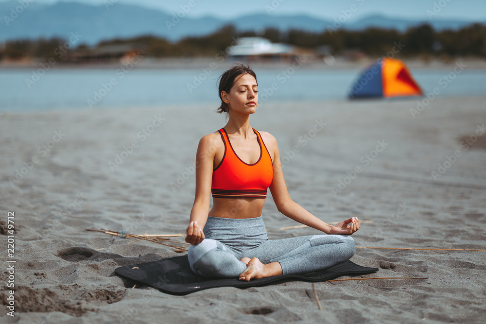Fototapeta premium Young woman stretching on the beach