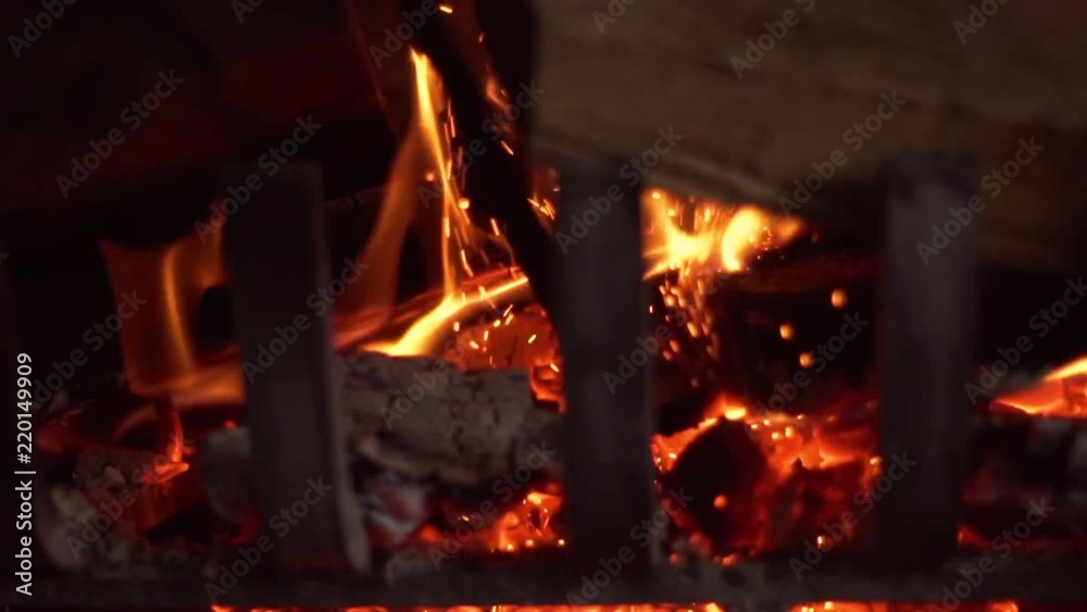 Wood burning in a fireplace dropping hot ash and embers, in slow motion Wood burning in a fireplace dropping hot ash and embers, in slow motion