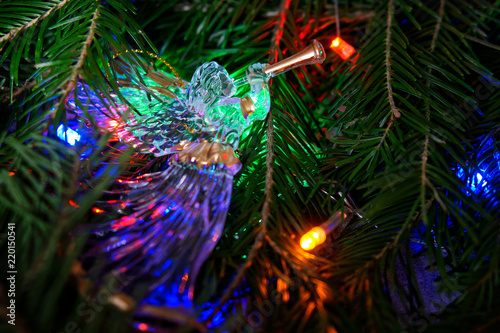 Christmas composition with a Christmas tree, an angel, and colorful lights.