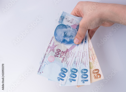 Hands holding American dollar banknotes and Turksh Lira banknotes side by side photo