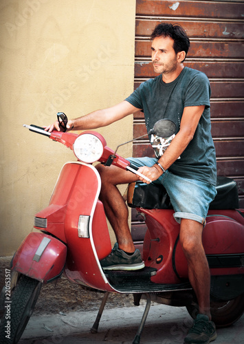 Man driving vintage scooter photo