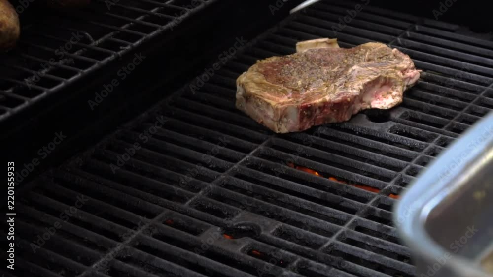 Grilling porterhouse steaks on a gas grill, slow motion Stock Video