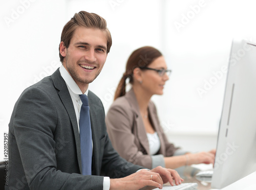 close up.smiling businessman with an assistant at the Desk