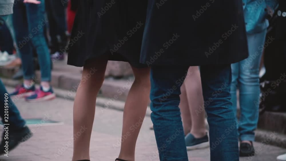 Beautiful close-up view of male and female legs doing a Latin American dance together at a fun street party slow motion. Beautiful close-up view of male and female legs doing a Latin American dance together at a fun street party slow motion.