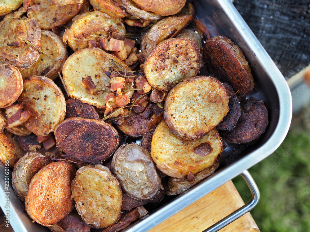 Roasted potatoes with bacon in baking pan. Overhead view.