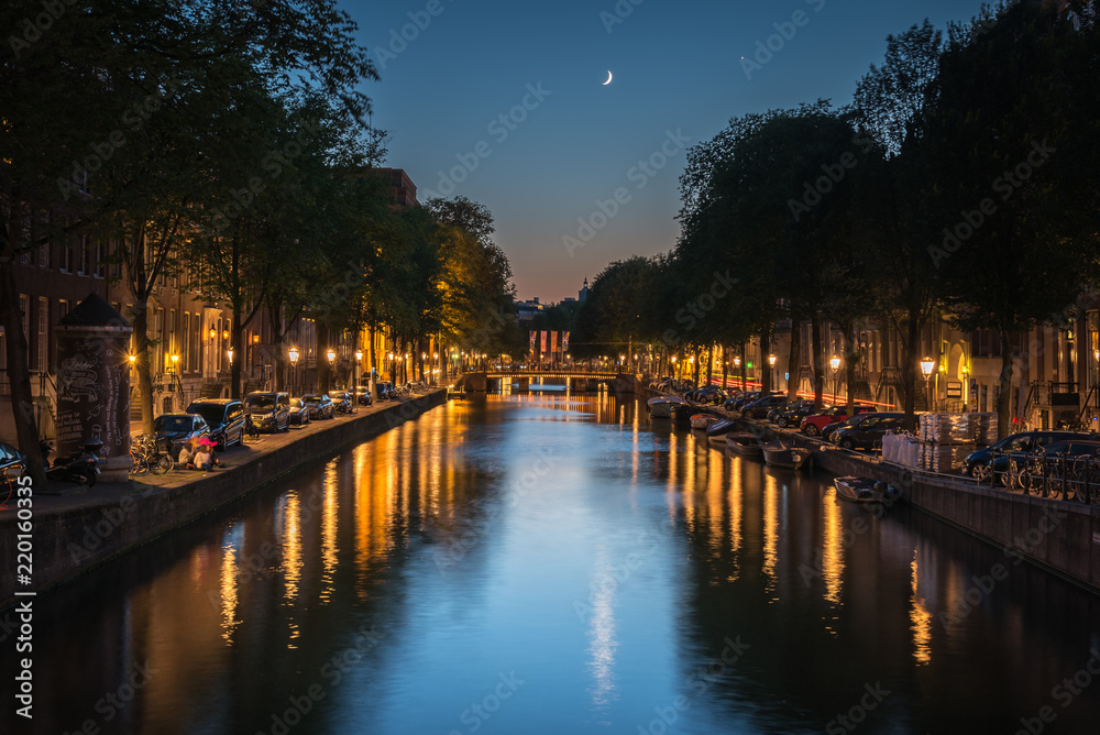 Fototapeta premium The moon reflected in the canal at night, Amsterdam, the Netherlands