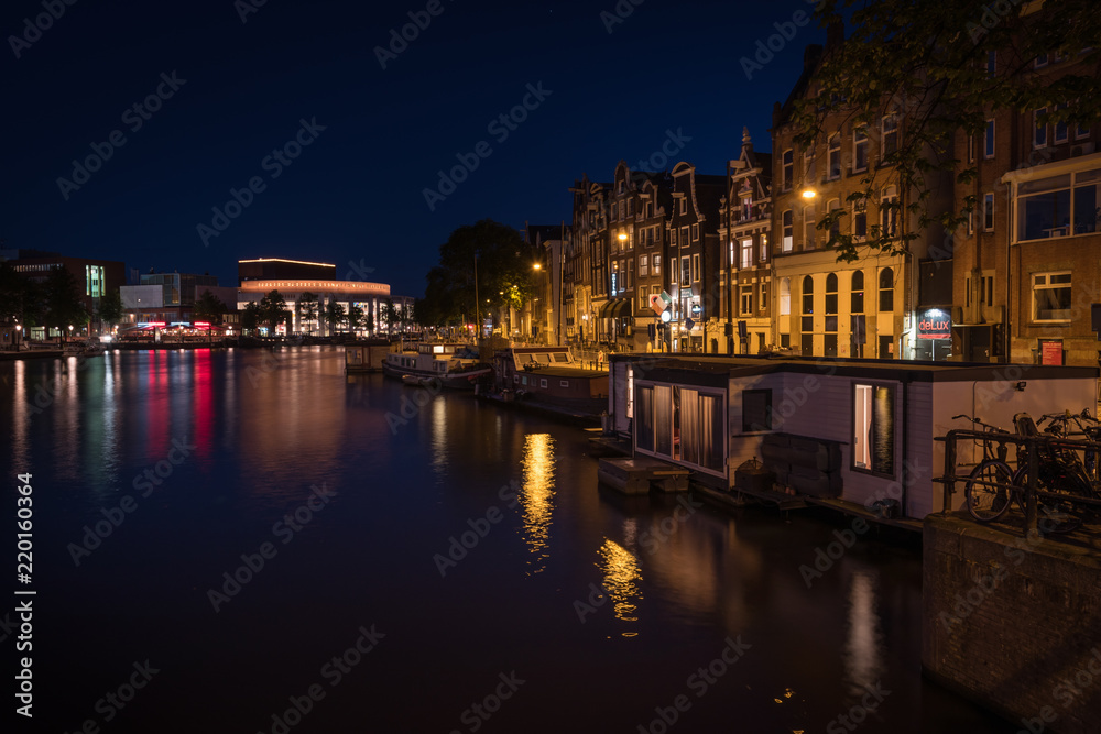 Reflection of the illuminated city of Amsterdam at night , Amsterdam, Netherlands.