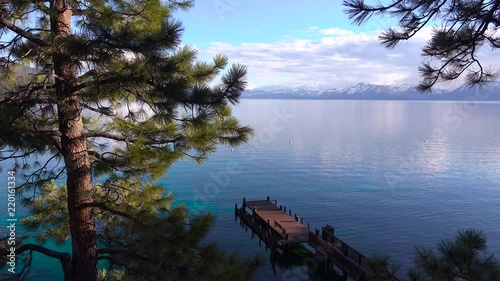 Pretty establishing shot of the shores of Lake Tahoe, Nevada with Sierras and pier.