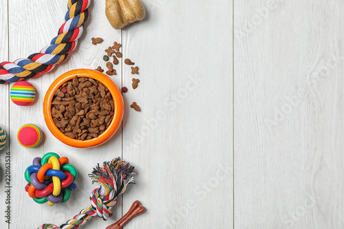Fototapeta Naklejka Na Ścianę i Meble -  Bowl with food for cat or dog and accessories on wooden background. Pet care