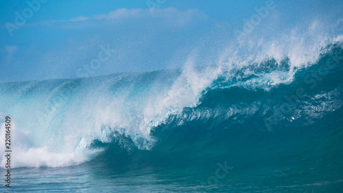 CLOSE UP: Raging barrel wave glimmers in the bright summer sunshine in Tahiti