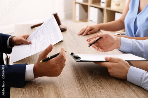Fotografie Lawyer working with clients at table in office, focus on hands