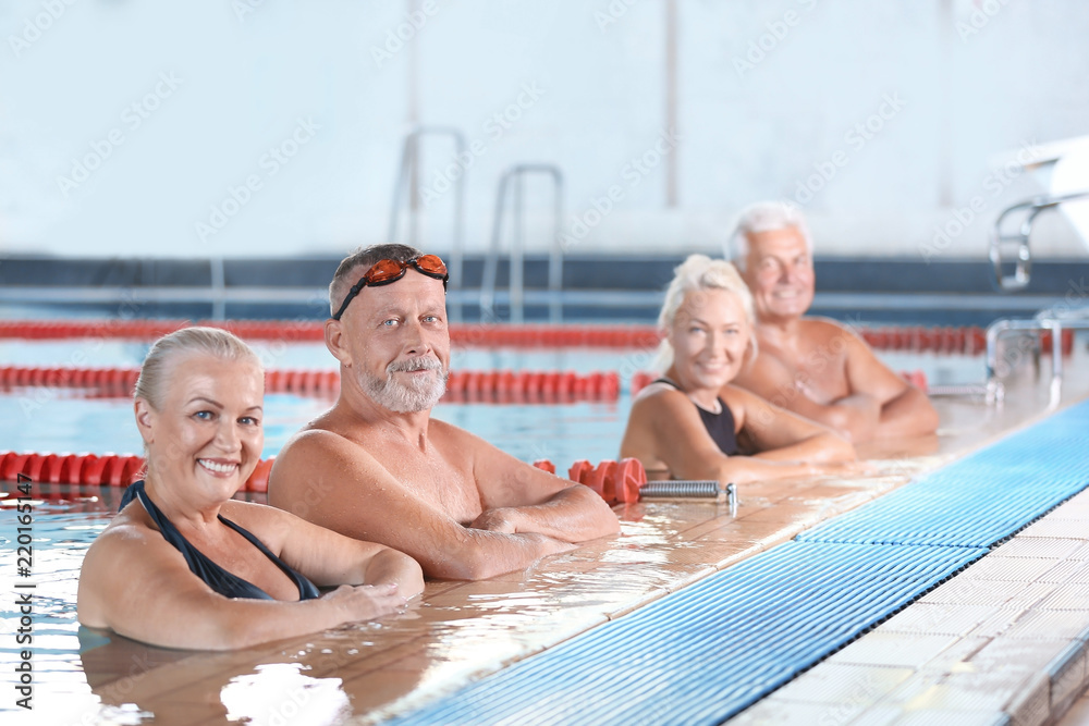 Fototapeta premium Sportive senior people in indoor swimming pool