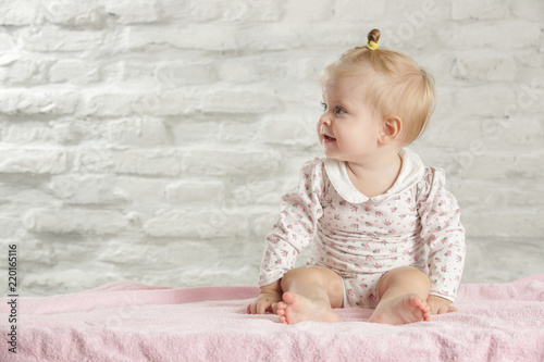 Portrait of a cute baby girl sitting in the room