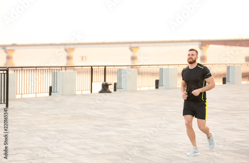 Young man running outdoors on sunny day