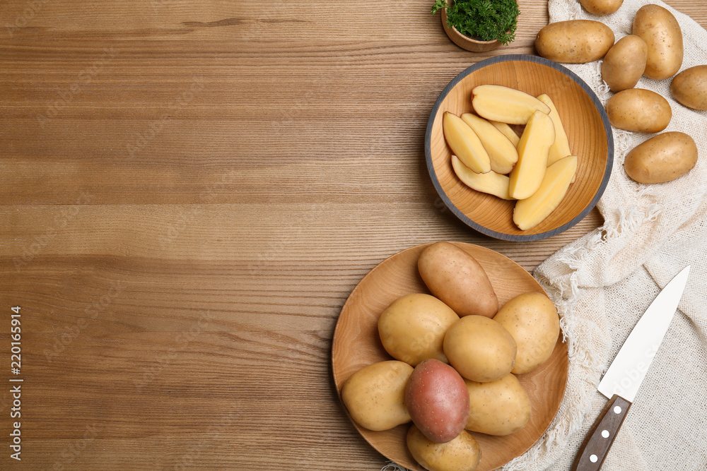 Flat lay composition with fresh organic potatoes and space for text on wooden background Flat lay composition with fresh organic potatoes and space for text on wooden background