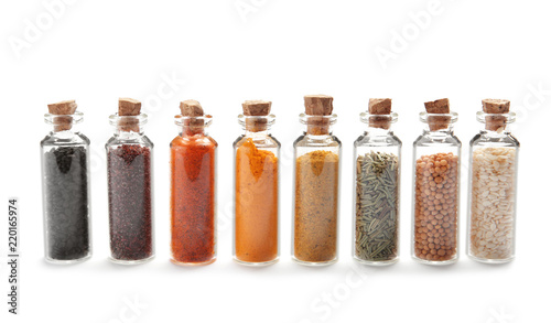 Fototapeta Naklejka Na Ścianę i Meble -  Row of small glass bottles with different spices on white background