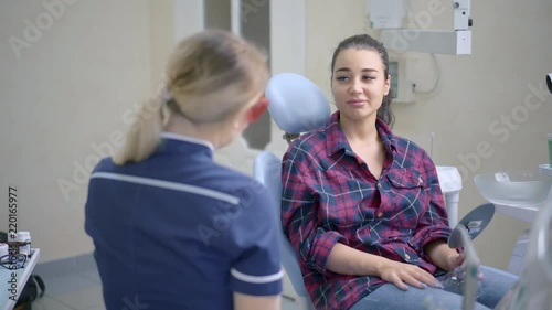 Female dentist talking with patient at dental clinic office
