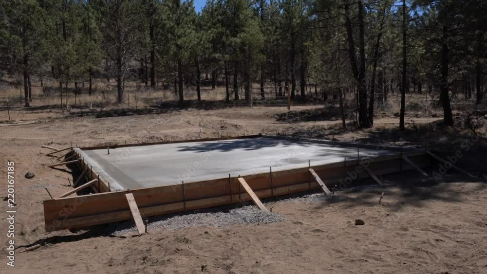 New barn foundation with trees in the background New barn foundation with trees in the background