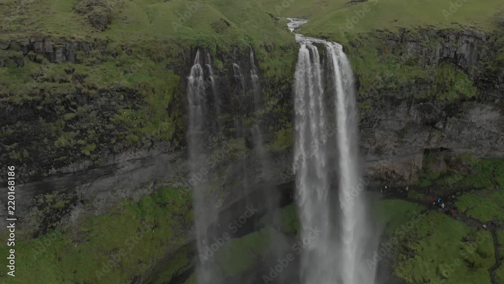 Aerial view to the mountains river flows through the valley and falls down. Waterfall Seljalandsfoss in Iceland. Aerial view to the mountains river flows through the valley and falls down. Waterfall Seljalandsfoss in Iceland.