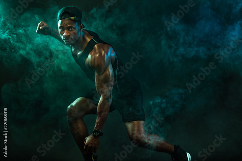 Sports men athlete on dark background. Power athletic guy bodybuilder doing fitness training. © Mike Orlov