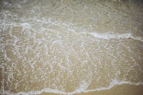 波の水しぶきと砂浜