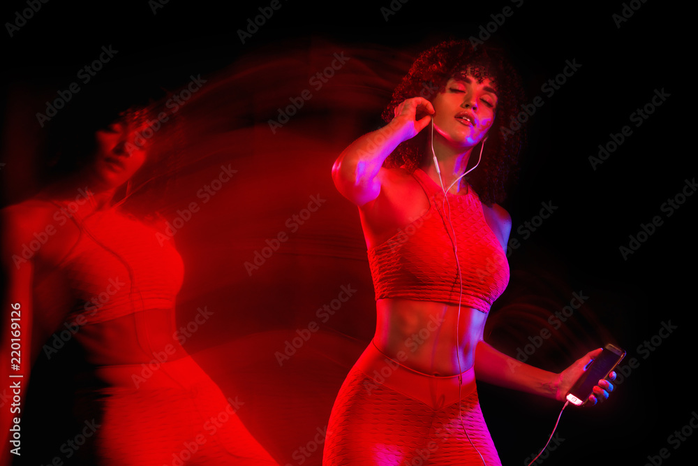 Naklejka premium Happy young and fitness woman dancing on black background