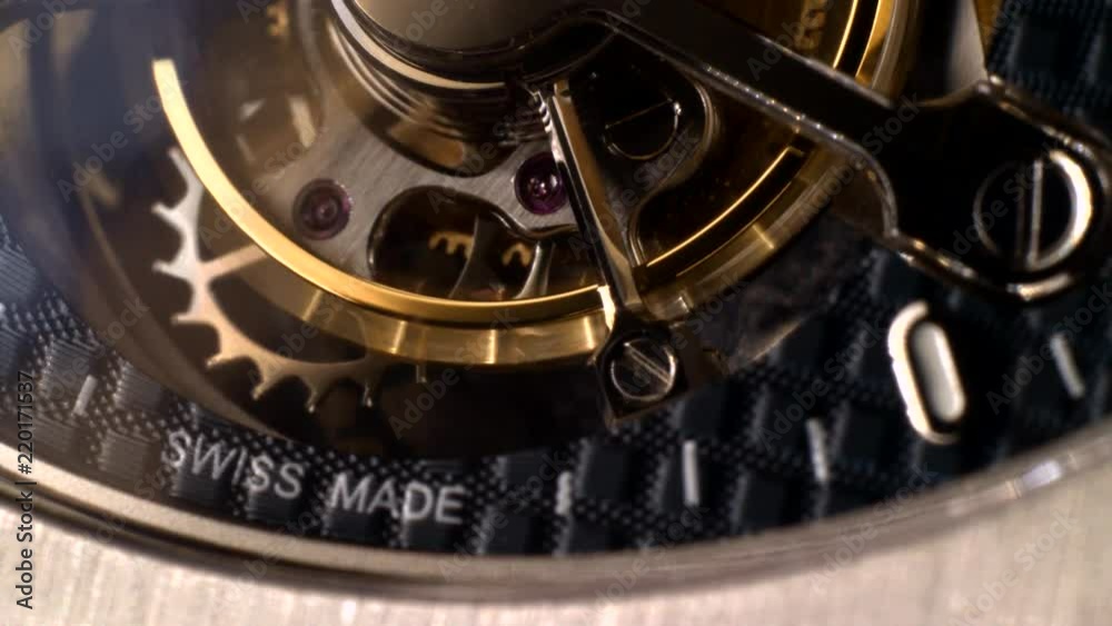 Mechanism of a watch with jewels. Open clockwork and fragments of shiny gears. Close up 4k macro shot. Time and work concept.