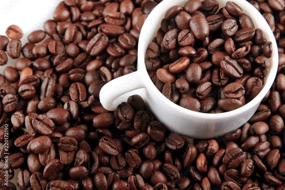 Mug full of, and surrounded by, coffee beans Mug full of, and surrounded by, coffee beans
