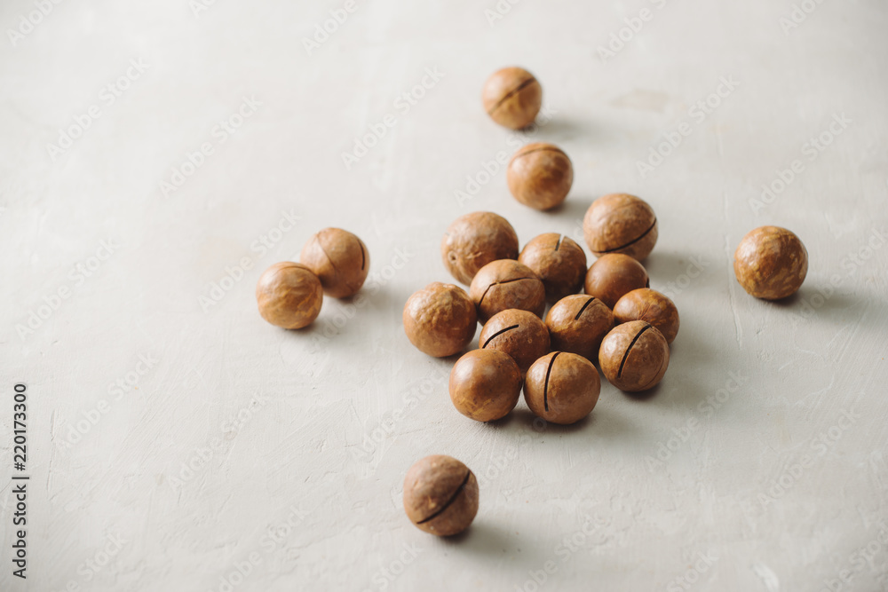 Superfood. Organic macadamia nut on stone background.