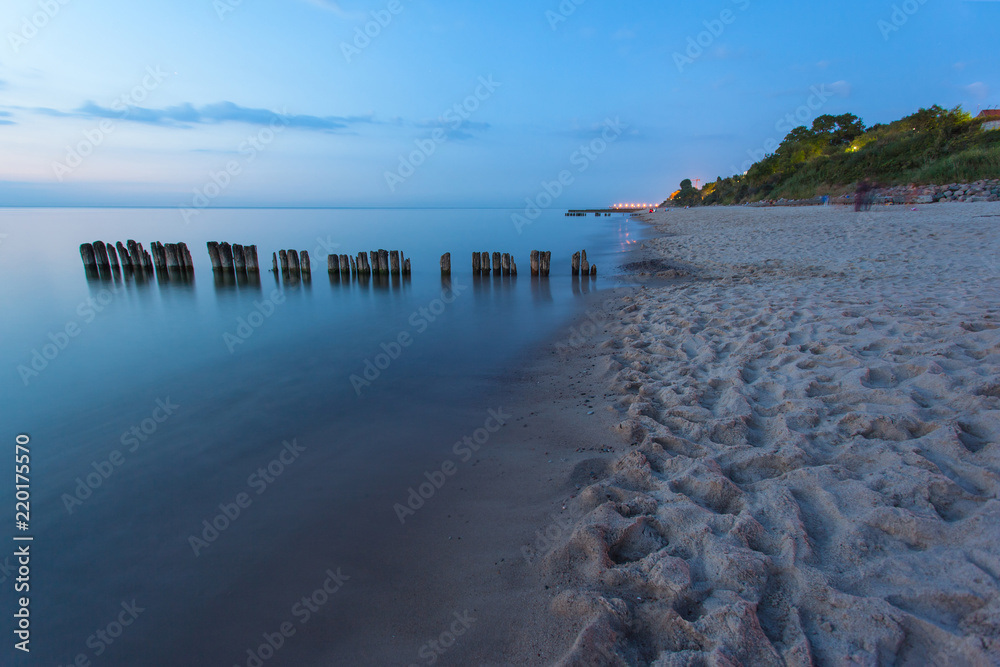 Fototapeta premium smooth sea surface and coast in blue twilight on long exposure