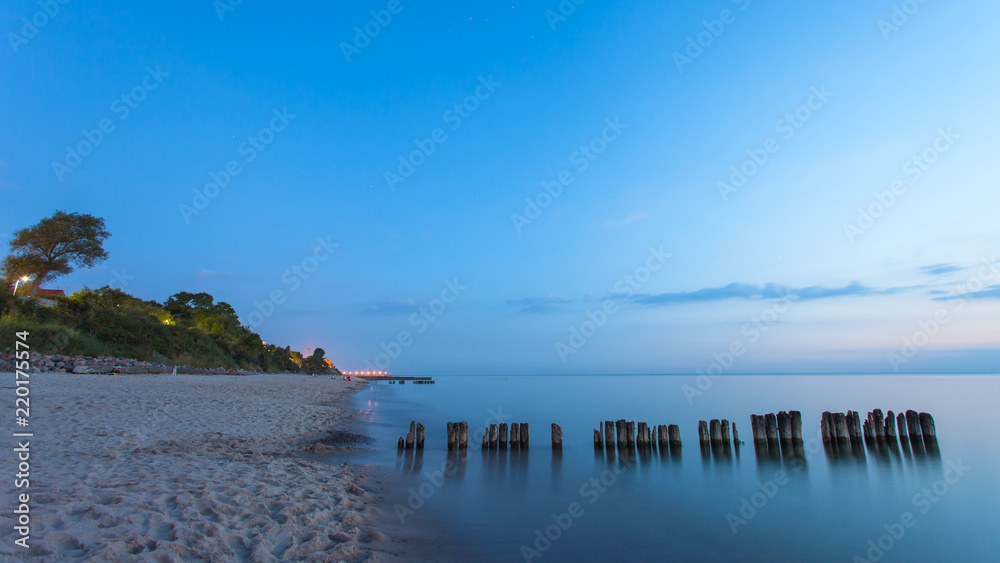 smooth sea surface and coast in blue twilight on long exposure