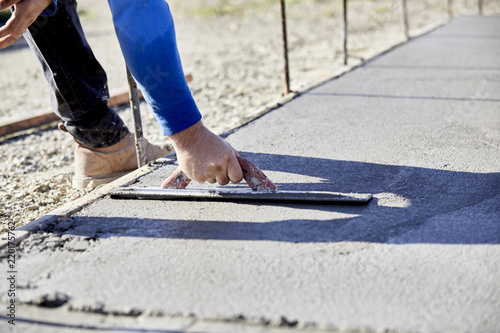 A mason using a trowel to finish a Slab