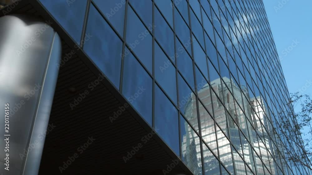 Tilt Up and Pan of Modern Business Office Buildings with Clouds and Blue Sky Reflection on Glass. 4K Tilt Up and Pan of Modern Business Office Buildings with Clouds and Blue Sky Reflection on Glass. 4K