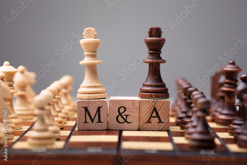King Chess Pieces With Mergers And Acquisitions Text photo