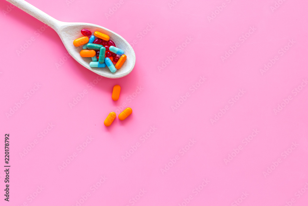 Reception of medicines concept. Pills in spoon on pink background top view space for text Reception of medicines concept. Pills in spoon on pink background top view space for text