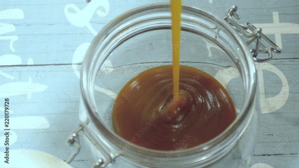pouring milk caramel in a glass jar to take as a family in the picnics pouring milk caramel in a glass jar to take as a family in the picnics