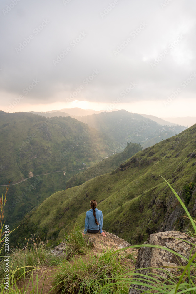 Woman sitting on the top of Small Adams peak near Ella, Sri Lanka