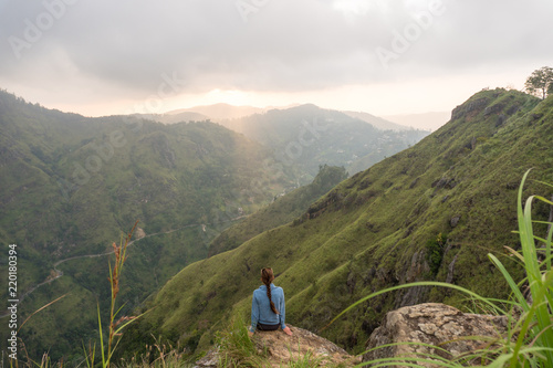 Woman enjoying beautiful view from the top of Small Adams peak. Ella, Sri Lanka.