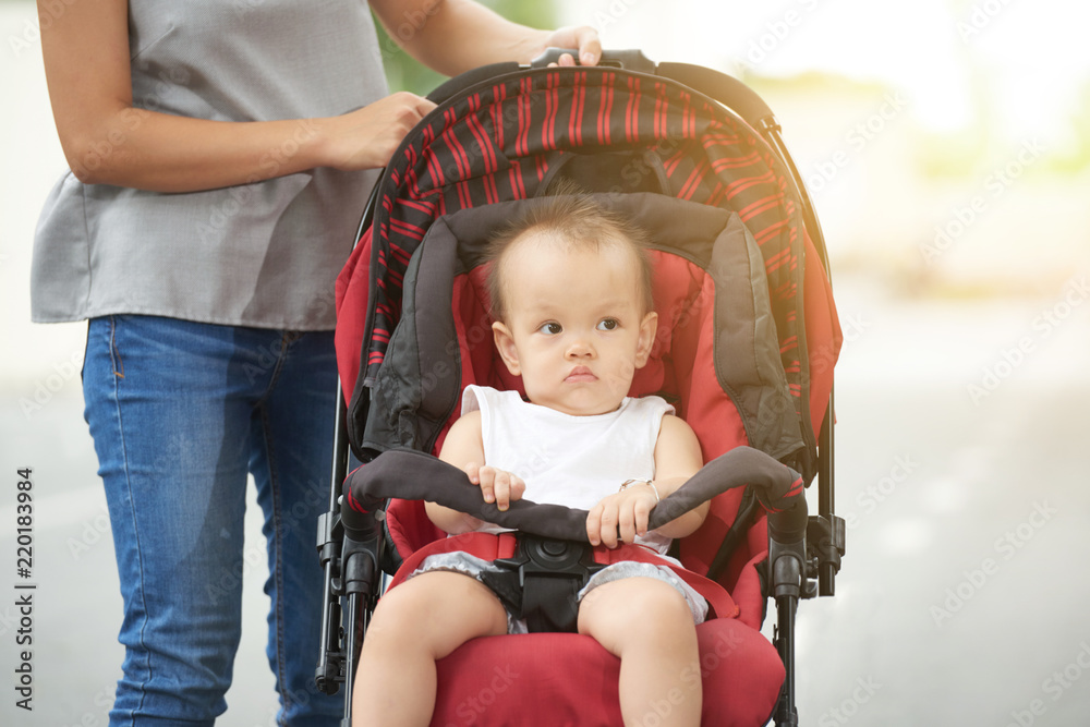 Little unsmiling mixed-race girl sitting in stroller Little unsmiling mixed-race girl sitting in stroller