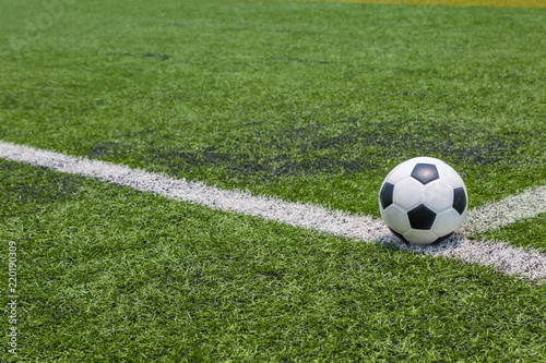 soccer ball on the white line on green soccer field grass