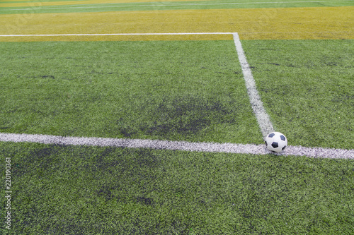soccer ball on the white line on green soccer field grass