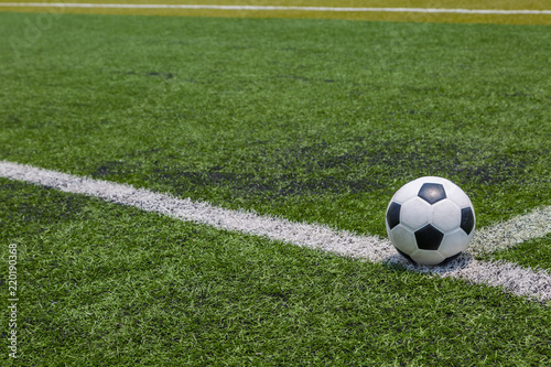 soccer ball on the white line on green soccer field grass © pandaclub23