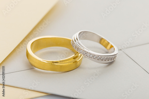 Gold and silver wedding rings on envelope background